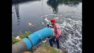 A member of PAC collecting sample of ‘black water’ from an outlet of a CETP in Ludhiana. The government should mark an inquiry into the functioning of CETPs as only then it will be able to reduce pollution in the Buddha Nullah, a member said. (HT PHOTO)