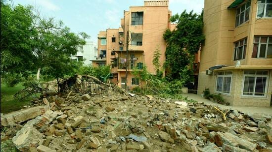 The 40m boundary wall of Jal Vayu Vihar collapsed on Tuesday morning while 12 workers were cleaning the drain adjacent to it as part of a drain repair work award by the Noida authority. (Sunil Ghosh/HT Photo)