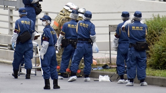 Police officers and firefighters investigate at the site where a man who was protesting a state funeral for former Japanese Prime Minister Shinzo Abe set himself on fire.(via REUTERS)