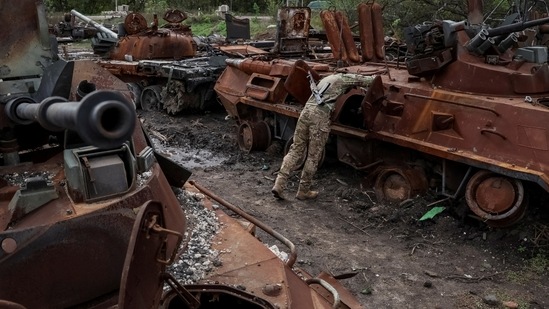 Russia-Ukraine War: Ukrainian serviceman checks a destroyed Russian Armoured Personnel Carrier (APC).(Reuters)