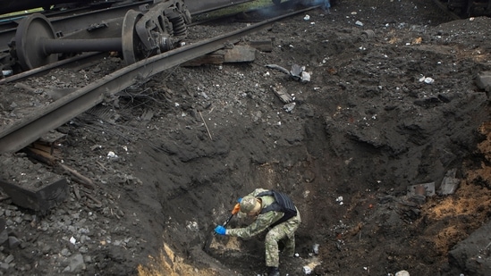 Russia-Ukraine War: A sapper inspects a crater left by a Russian missile strike.(Reuters)