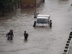 Commuters push their vehicle down the waterlogged Delhi-Gurugram Expressway service road after rainfall in Gurugram on Thursday, (PTI) Commuters push their vehicle down the waterlogged Delhi-Gurugram Expressway service road after rainfall in Gurugram on Thursday, (PTI)