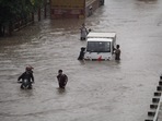 Commuters push their vehicle down the waterlogged Delhi-Gurugram Expressway service road after rainfall in Gurugram on Thursday, (PTI) Commuters push their vehicle down the waterlogged Delhi-Gurugram Expressway service road after rainfall in Gurugram on Thursday, (PTI)