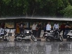 Commuters take shelter from the rain in Gurugram. (Vipin Kumar/HT Photo) Commuters take shelter from the rain in Gurugram. (Vipin Kumar/HT Photo)