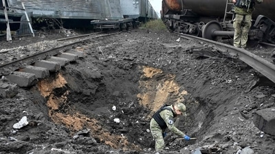 Russia-Ukraine War: A forensic explosives expert examines a crater from a missile explosion at a freight railway station in Kharkiv. (AFP) Russia-Ukraine War: A forensic explosives expert examines a crater from a missile explosion at a freight railway station in Kharkiv. (AFP)