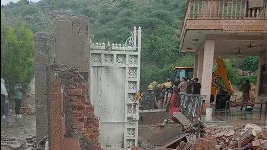 The boundary walls and the house were razed down using two earth moving machines in the presence of more than 50 police personnel, including Suresh Kumar, assistant commissioner of police, Manesar at around 5 pm. (HT Photo)