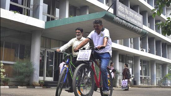 OP Chaudhary (left) and Rakesh Sharda also cycled within the PAU campus in Ludhiana to spread environmental awareness among their colleagues and students. (Gurpreet Singh/HT)