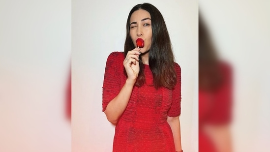 Karisma Kapoor added that extra spice to her pictures by posing with a red lollipop, matching with the theme.(Instagram/@therealkarismakapoor)