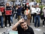 A man cuts his hair during a demonstration in support of Mahsa Amini in front of the Iranian embassy in Brussels on Saturday, following the death of an Iranian woman after her arrest by the country's morality police in Tehran.(AFP) A man cuts his hair during a demonstration in support of Mahsa Amini in front of the Iranian embassy in Brussels on Saturday, following the death of an Iranian woman after her arrest by the country's morality police in Tehran.(AFP)