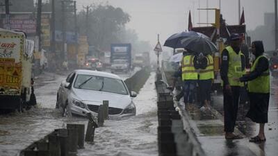 A car stuck on a waterlogged road in heavy rain on NH-48 in Narsinghpur village, Gurugram, on Friday. (Parveen Kumar/HT Photo)