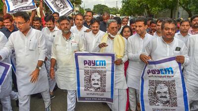 Congress leaders hold posters with QR code and the phrase ‘PayCM’ during a protest against the Karnataka government on the issue of corruption, in Bengaluru on Friday. (PTI)