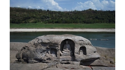 At the Foyeliang island reef, three 600-year-old Buddhist statues, carved into a boulder, are now visible. They date to the Ming and Qing dynasties. The largest is about 1 metre high and depicts a monk sitting on a lotus pedestal, flanked by two junior monks, presumably blessing boats as they pass by. (Thomas Peter/REUTERS) At the Foyeliang island reef, three 600-year-old Buddhist statues, carved into a boulder, are now visible. They date to the Ming and Qing dynasties. The largest is about 1 metre high and depicts a monk sitting on a lotus pedestal, flanked by two junior monks, presumably blessing boats as they pass by. (Thomas Peter/REUTERS)