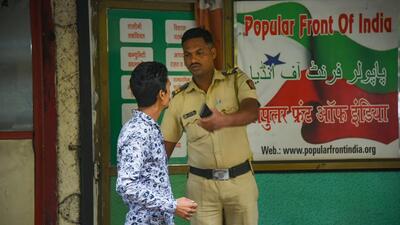 A security person keeps vigil outside a Popular Front of India office during the NIA raids on Thursday. (PTI Photo)