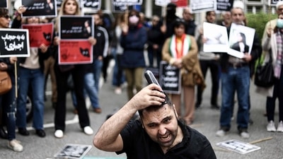 A man cuts his hair during a demonstration in support of Mahsa Amini in front of the Iranian embassy in Brussels on Saturday, following the death of an Iranian woman after her arrest by the country's morality police in Tehran. (AFP) A man cuts his hair during a demonstration in support of Mahsa Amini in front of the Iranian embassy in Brussels on Saturday, following the death of an Iranian woman after her arrest by the country's morality police in Tehran. (AFP)