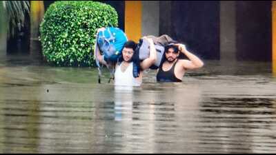 People wading through waist-deep water in Aligarh on Friday. (HT)