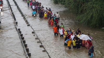 Gurugram: Commuters wade through the waterlogged Delhi-Gurugram Expressway service road after rainfall. (PTI) Gurugram: Commuters wade through the waterlogged Delhi-Gurugram Expressway service road after rainfall. (PTI)