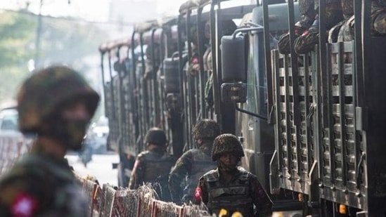 Myanmar: A soldier stand next to military vehicles as people gather to protest against a military coup in Yangon, Myanmar.