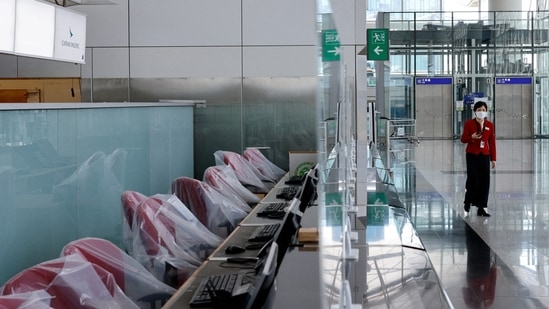 Covid In Hong Kong: A crew member of Cathay Pacific walks at the Hong Kong International Airport Departure Hall.(Reuters)