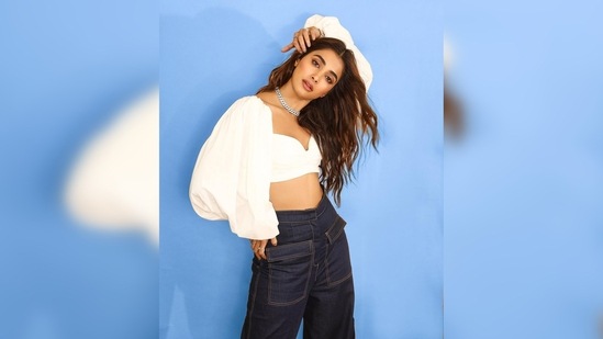 In the pictures shared by Pooja Hegde on her Instagram handle, the actor can be seen wearing a white crop top and flared pants.(Instagram/@hegdepooja)