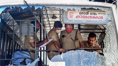 Police personnel take stock of the damages done to a Kerala State Road Transport Corporation bus after some miscreants threw stones on it, (PTI) Police personnel take stock of the damages done to a Kerala State Road Transport Corporation bus after some miscreants threw stones on it, (PTI)