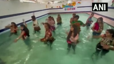 The image, taken from the Twitter video, shows dancers doing Garba while standing in a swimming pool. (Twitter/@AHindinews)