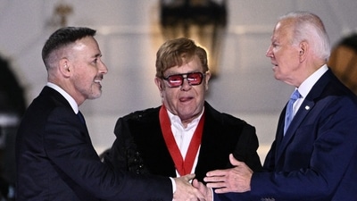 British singer Elton John and his husband David Furnish stand on stage with US President Joe Biden. (AFP) British singer Elton John and his husband David Furnish stand on stage with US President Joe Biden. (AFP)