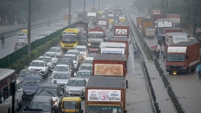 Vehicles wade through a waterlogged stretch during heavy rain. (Parveen Kumar/Hindustan Times)