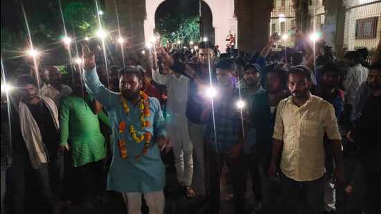 Students of AU protesting against fee hike taking out a march with flashlights of their mobile phones switched on, on Saturday night. (HT Photo)