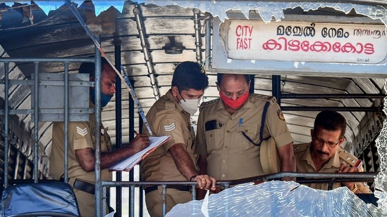 Thiruvananthapuram: Police personnel take stock of the damages done to a Kerala State Road Transport Corporation bus after some miscreants threw stones on it, during the 'hartal' called by PFI.(PTI)