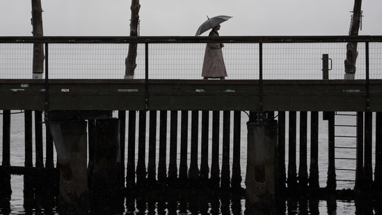 Hurricane Fiona In Canada: A pedestrian walks across a footbridge.(AP)