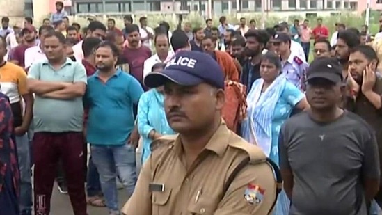 A large crowd gather outside AIIMS Rishikesh where the young reception's autopsy was conducted. (ANI Photo)