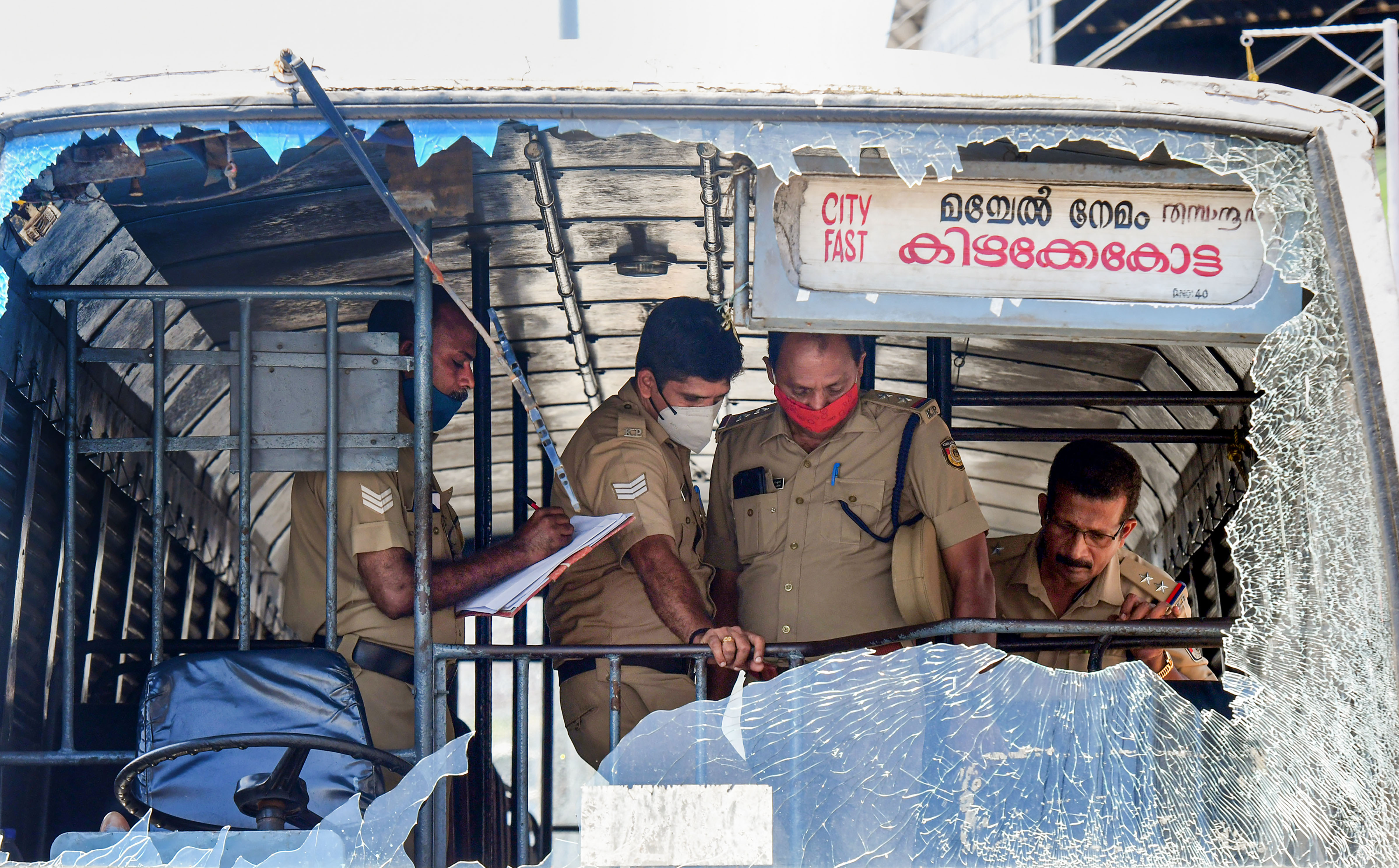 Thiruvananthapuram: Police personnel take stock of the damages done to a Kerala State Road Transport Corporation bus after some miscreants threw stones on it, during the 'hartal' called by PFI. (PTI) Thiruvananthapuram: Police personnel take stock of the damages done to a Kerala State Road Transport Corporation bus after some miscreants threw stones on it, during the 'hartal' called by PFI. (PTI)