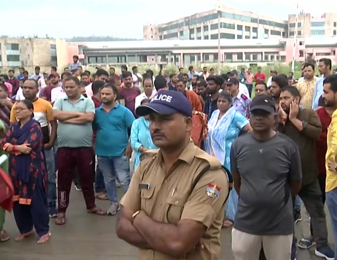 A large crowd gather outside AIIMS Rishikesh where the young reception's autopsy was conducted. (ANI Photo)