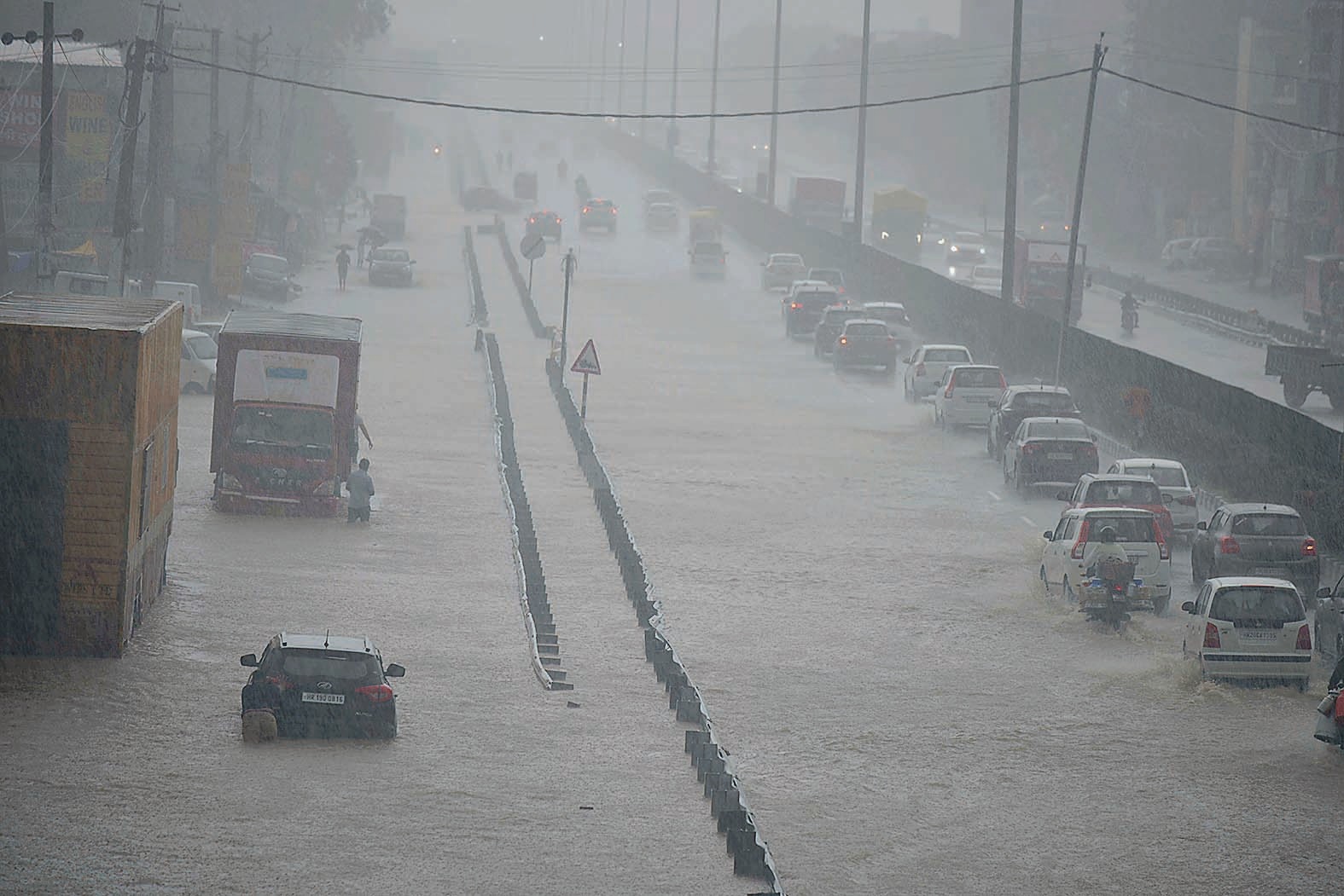 Vehicles wade through a waterlogged stretch in heavy rain on the NH-48 service road near Narsinghpur village in Gurugram on Saturday. (Parveen Kumar/HT Photo) Vehicles wade through a waterlogged stretch in heavy rain on the NH-48 service road near Narsinghpur village in Gurugram on Saturday. (Parveen Kumar/HT Photo)