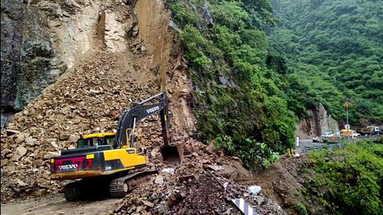 National Highway 707 was blocked for traffic due to a landslide at Gangtoli in Shillai tehsil of near Hevna temple in Sirmaur, Himachal, on Sunday. Three people feared drowned in Chamba district after a flash flood due to heavy rain. (HT Photo)