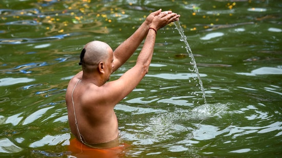 In Mumbai, a man takes a dip in the historic Banganga water tank as he pays homage to his ancestors through prayers and food offerings on the last day of ‘Pitru Paksha,' on Sunday.(PTI)