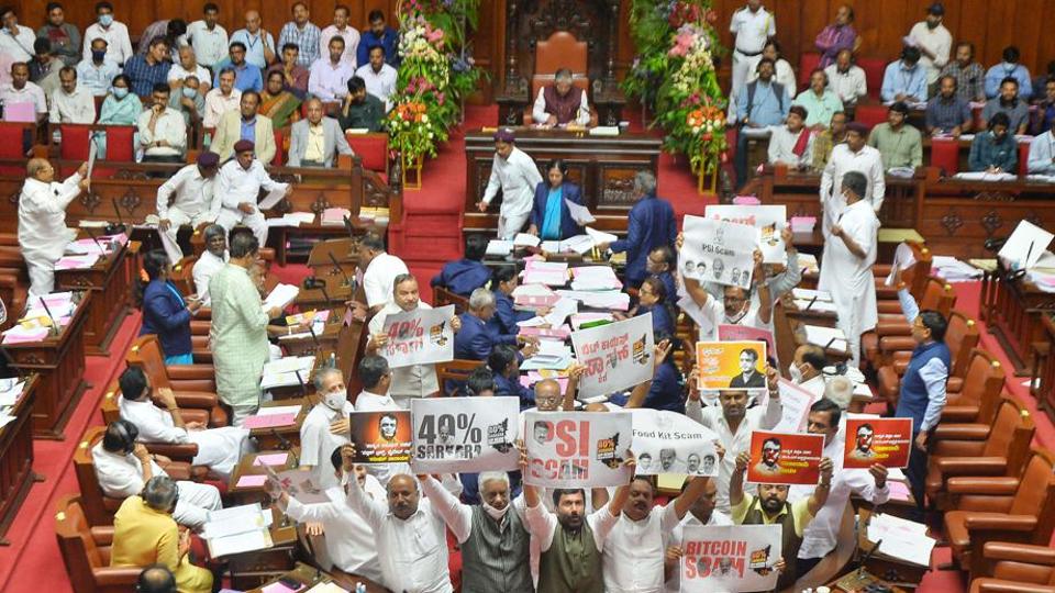 Congress and JD(S) members hold placards against government, during a legislative council session, in Vidhana Soudha. (PTI) Congress and JD(S) members hold placards against government, during a legislative council session, in Vidhana Soudha. (PTI)