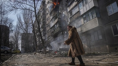 A woman walks past a burning apartment building after shelling in Mariupol, Ukraine. (File image) (AP) A woman walks past a burning apartment building after shelling in Mariupol, Ukraine. (File image) (AP)