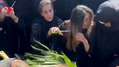 Iran Anti-Hijab Protests: Javad Heydari's sister can be seen cutting off her hair. (Twitter) Iran Anti-Hijab Protests: Javad Heydari's sister can be seen cutting off her hair. (Twitter)