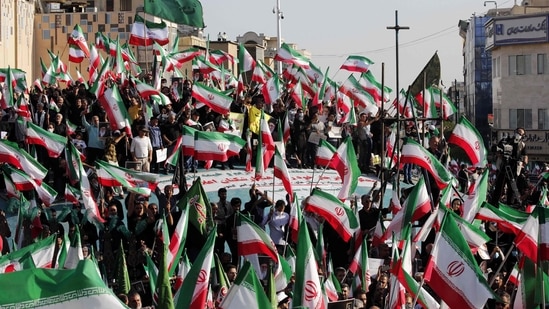 Iran Anti-Hijab Protests: Iranian pro-government protesters wave their national flag during a rally against the recent anti-government protests in Iran, in Tehran.(AFP)