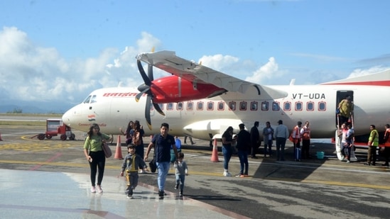 Passengers alighting from the Alliance Air flight at Jubbarhatti airport, 24km from Shimla, after flights resumed on Monday. (Deepak Sansta/HT) Passengers alighting from the Alliance Air flight at Jubbarhatti airport, 24km from Shimla, after flights resumed on Monday. (Deepak Sansta/HT)