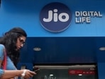 A woman checks her mobile phone as she walks past a mobile store of Reliance Jio, in Mumbai.(Reuters File) A woman checks her mobile phone as she walks past a mobile store of Reliance Jio, in Mumbai.(Reuters File)