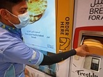 A man collects items from a vending machine that gives out free bread in Dubai.(AFP) A man collects items from a vending machine that gives out free bread in Dubai.(AFP)