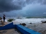 A woman takes photos while waves crash against a seawall as Hurricane Ian passes through George Town, Grand Cayman island. A woman takes photos while waves crash against a seawall as Hurricane Ian passes through George Town, Grand Cayman island.