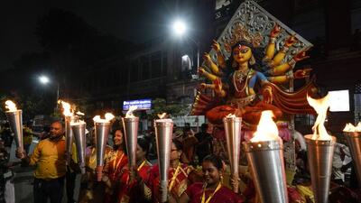 Women hold torches as they welcome an idol of goddess Durga into their neighbourhood ahead of Durga Puja festival in Kolkata on Sept. 27. Durga Puja festival will be celebrated from Oct 2 to 5. (AP) Women hold torches as they welcome an idol of goddess Durga into their neighbourhood ahead of Durga Puja festival in Kolkata on Sept. 27. Durga Puja festival will be celebrated from Oct 2 to 5. (AP)