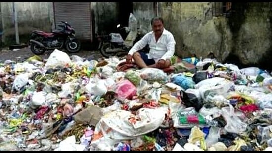 Auto rickshaw driver Manoj Waghmare sitting amidst garbage at Mahatma Phule Chowk in Kalyan during his two-day protest over the weekend. His efforts bore fruits as KDMC officials cleared the garbage on Monday. (PRAMOD TAMBE/HT PHOTO)