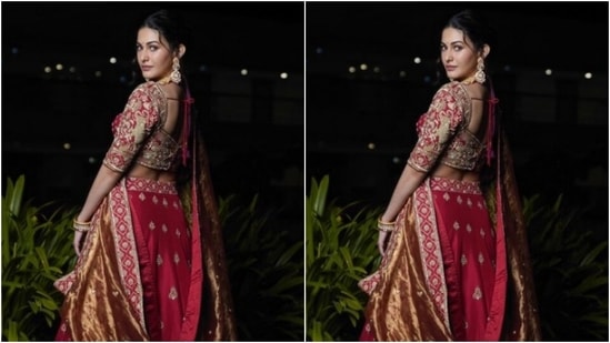 Amyra dressed up as a bride in a red blouse heavily embellished in golden zari details. She further teamed it with a long and flowy red silk skirt that came embellished in golden zari.(Instagram/@amyradastur93)