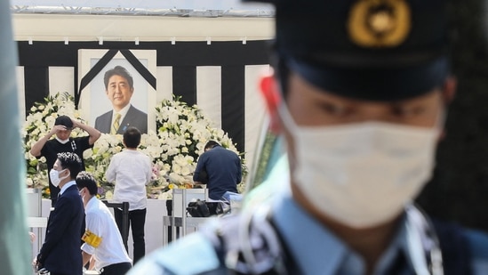 Funeral de Estado Shinzo Abe: Um policial fica de pé enquanto o público (atrás) presta homenagem ao ex-primeiro-ministro japonês Shinzo Abe. (AFP)