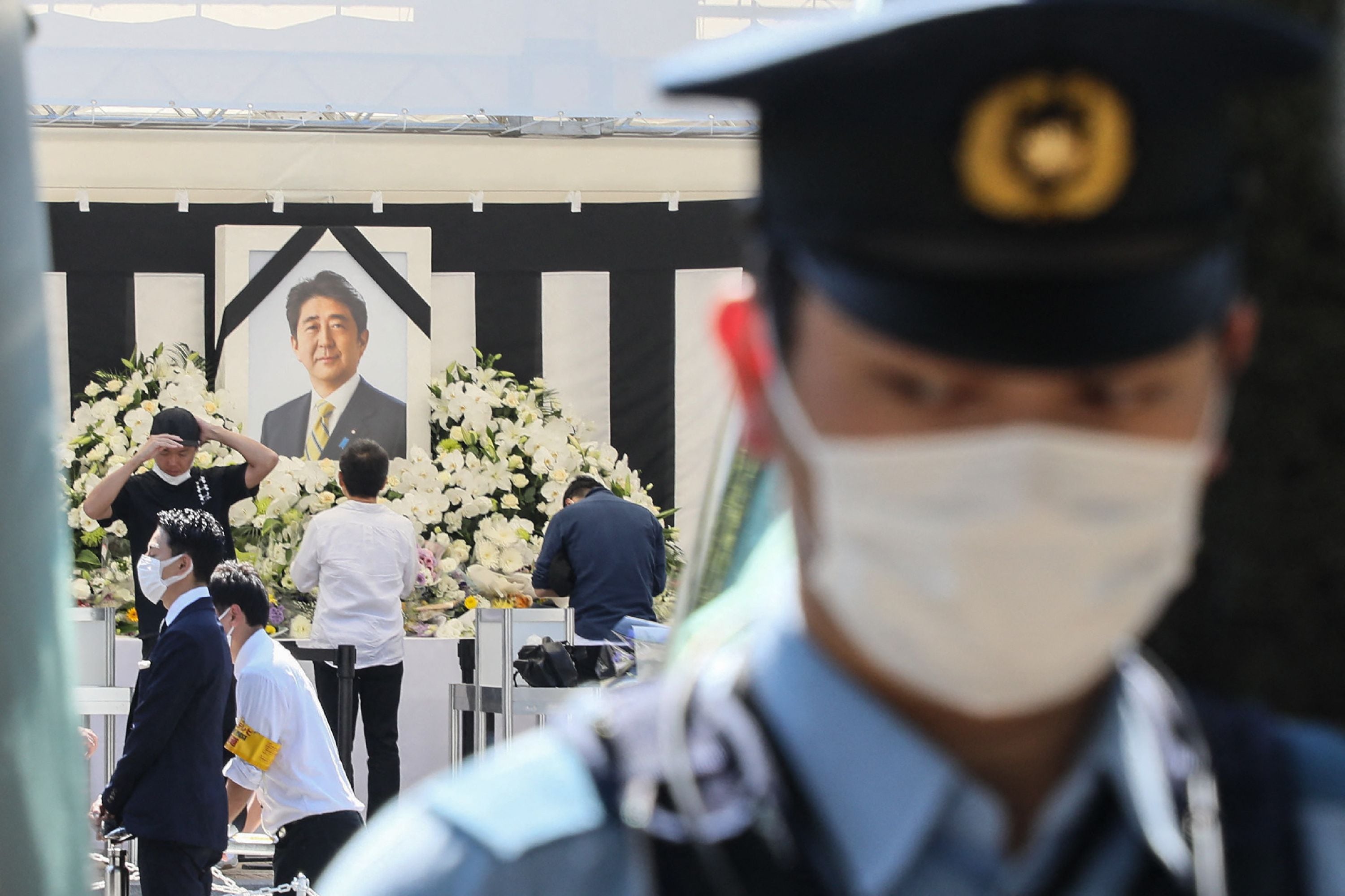 Shinzo Abe State Funeral: A policeman stands by as members of the public (behind) pay their respects to former Japanese prime minister Shinzo Abe. (AFP) Shinzo Abe State Funeral: A policeman stands by as members of the public (behind) pay their respects to former Japanese prime minister Shinzo Abe. (AFP)