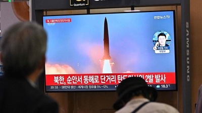 People watch a television screen showing a news broadcast with file footage of a North Korean missile test, at a railway station in Seoul. (AFP)